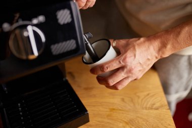 Anonim bir barista kahveli cappuccino yapıyor, erkek barista el modern kafedeki öğütülmüş kahve makinesinden espresso yapıyor