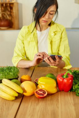 Kadın dijital tablet ya da akıllı tablet kullanıyor, evde yemek tarifi arıyor, sağlıklı gıda konsepti, vegan ya da diyet. İnternetten alışveriş.