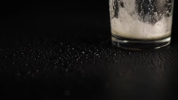 Close up of empty beer glass with foam on black background — Stock Video