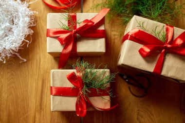 Noel çevre dostu ambalaj kağıdı ve köknar dalları Bayram sezonu için hediyeler ahşap masa üzerinde Noel, ekolojik dekor, Noel hediye kutusu