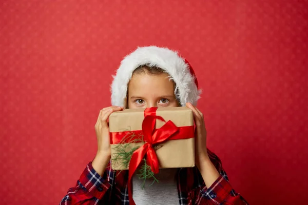 Menina Bonito Santa Chapéu Segurando Presentes Natal Frente Seu Rosto — Fotografia de Stock