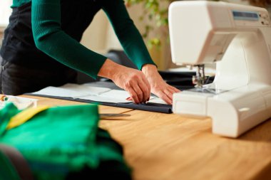 Adım adım, kadın terzinin dikiş kalıpları atölye, tekstil endüstrisi, hobi, çalışma alanı gibi dikiş desenleriyle çalışan olgun bir terzi. Oluşturma süreci DIY, Terzinin İş Yeri.