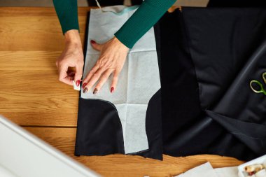 Tepeden tırnağa kadın terzinin dikiş kalıpları atölye, tekstil endüstrisi, hobi ve çalışma alanında dikiş desenleriyle çalışan olgun bir terzi. Oluşturma süreci DIY, Terzinin İş Yeri