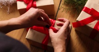 Tanınmayan bir kadının elleri Noel hediyesi paketliyor, çevre dostu ambalaj kağıdı hediyeleri, Noel hediyesini paketleyen bir kadın, hediye kutusu.