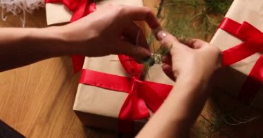 Tanınmayan bir kadının elleri Noel hediyesi paketliyor, çevre dostu ambalaj kağıdı hediyeleri, Noel hediyesini paketleyen bir kadın, hediye kutusu.