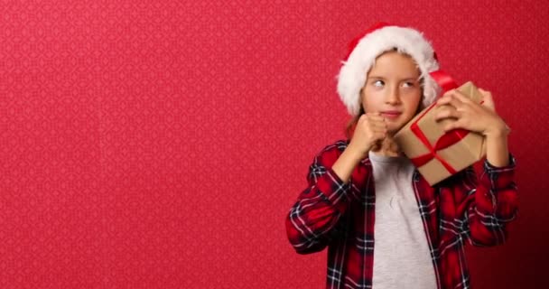 Surpreendida Positiva Menina Santa Chapéu Segurando Presente Natal Verificando Caixa — Vídeo de Stock