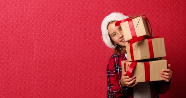 Αστείο Μικρό Κορίτσι Στο Καπέλο Σάντα Πολλά Κουτιά Δώρων Χριστούγεννα — Αρχείο Βίντεο