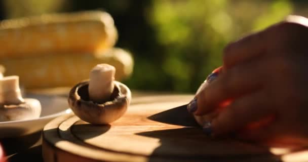 屋外での週末のバーベキュー中に木の板の上で新鮮なキノコの野菜を切断する認識できない女性は グリル 夏の家族のピクニック 自然上の食品の準備 — ストック動画