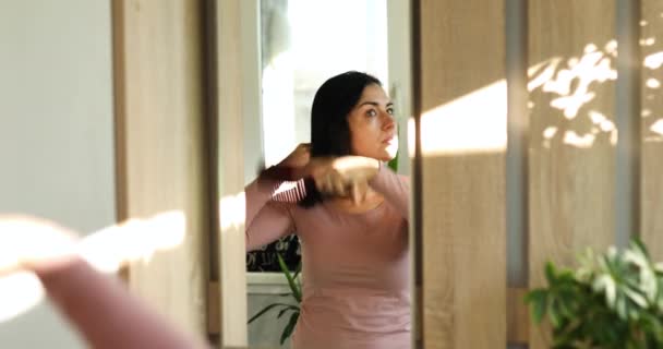 Mujer Bastante Morena Cepillando Cabello Con Peine Delante Del Espejo — Vídeo de stock