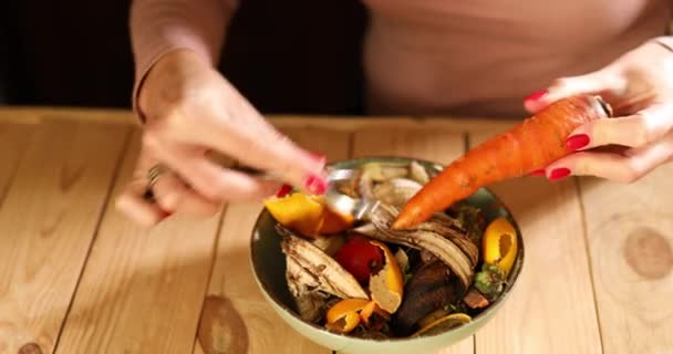 Женщины Очищают Морковь Кожуры Овощной Пилинг Бросают Компостное Ведро Остатки — стоковое видео