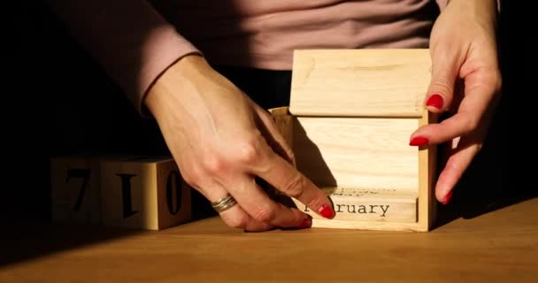 Kvinna hand förändring, fastställer datum på trä kalendern den 14 februari — Stockvideo