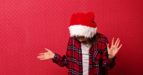 Funny little girl in santa hat, fall Christmas gift boxes arise in hand isolated on red background, — Stock Video