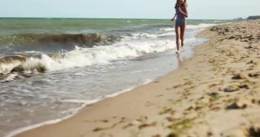 Mutlu, neşeli küçük kız sahilde koşuyor, deniz ailesi tatilinde, deniz kenarında tatil yapıyor.