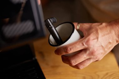 Anonim bir barista kahveli cappuccino yapıyor, erkek barista el modern kafedeki öğütülmüş kahve makinesinden espresso yapıyor