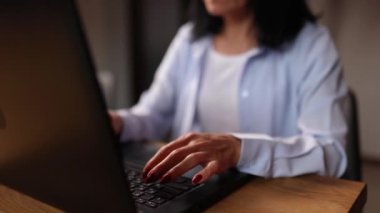Evde dizüstü bilgisayarla çalışan yetişkin bir kadın, uzaktan kumanda için bilgisayarda yazan yaşlı bir kadın.