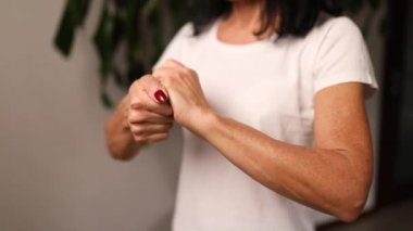 Slow motion Mature woman applying moisturizing hand cream at home, Concept of health care of the hand