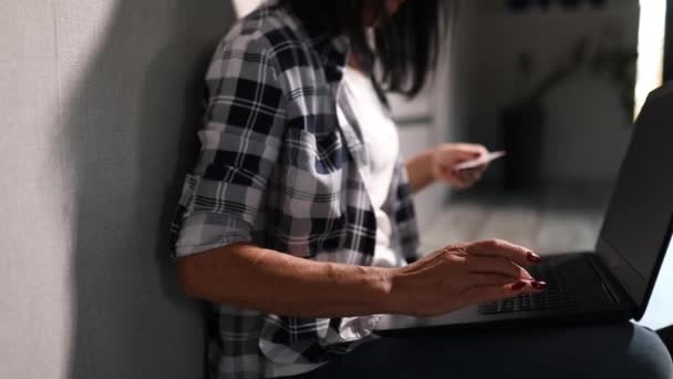 ラップトップコンピュータを搭載したシニア女性は クレジットカード情報 オンラインショッピング 予約ホテルの支払い 自宅でオンライン決済を入力します — ストック動画