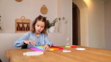 Mutlu duygusal, hiperaktif küçük kız büyük silikon popitle oynuyor, basit gamze, kabarcık oyuncağı, evde stres önleyici duyusal oyuncak, surat yap. Akıl sağlığı oyuncağı konsepti