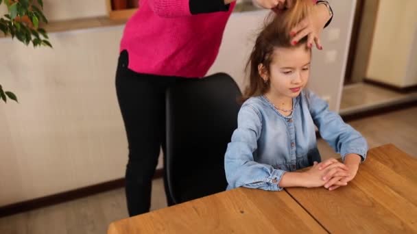 母が来て ブラッシングし 彼女の娘の髪のためのヘアスタイルを作ります自宅で ケア家族の瞬間 一緒に時間を過ごす — ストック動画