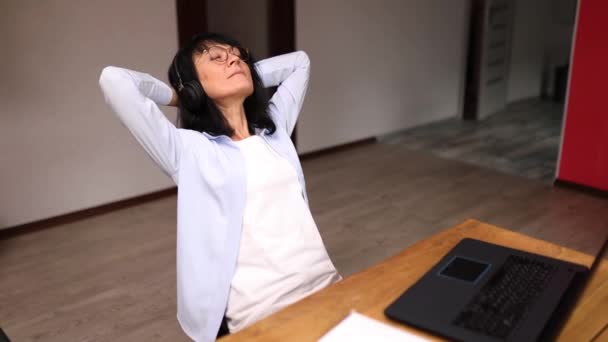 Business mature woman relaxing wearing headphone and listening music — Stock videók