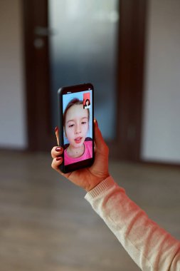 Mutlu büyükannem cep telefonuyla torunuyla internetten konuşuyor, uzaktan iletişim kuruyor, olgun kadın evdeki koltukta oturuyor, akıllı telefon kullanıyor, teknoloji kavramı kullanıyor.