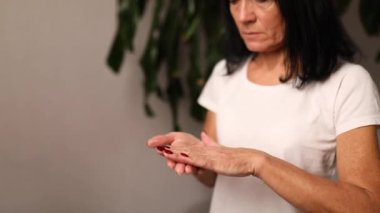 Evde nemlendirici el kremi süren olgun bir kadın, el bakımı kavramı.