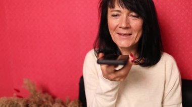 Mutlu, gülümseyen, cep telefonu tutan, arkadaşlarıyla ya da ailesiyle konuşan son sınıf öğrencisi bir kadın. Hoparlör kullanıyor, yeni teknoloji kavramı. Olumlu, olgun bir bayan arkadaşınla akıllı telefondan konuşmaktan zevk alır..