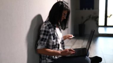 Laptop bilgisayarı ve kredi kartı olan, internetten alışveriş yapan, rezervasyon otelini ödeyen, evde oturarak online ödeme yapan olgun, çekici bir kadın..