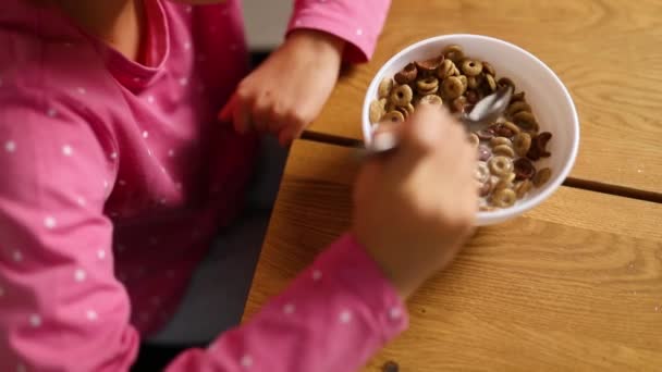 可爱的小女孩喜欢吃带有牛奶的麦片当早餐 吃起来很有胃口 多么美味的健康食品 漂亮的孩子在家里吃早餐的慢动作 — 图库视频影像