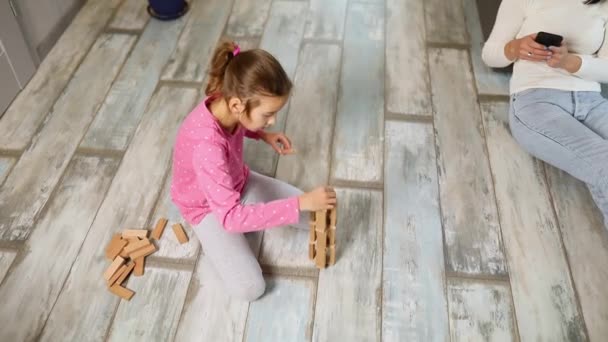 Indifferent Mother Use Mobile Phone Daughter Play Wooden Construction Floor — ストック動画