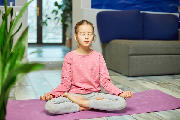 Söt Liten Flicka Sitter Träningsmatta Lotusposition Medan Gör Yoga Hemma — Stockfoto