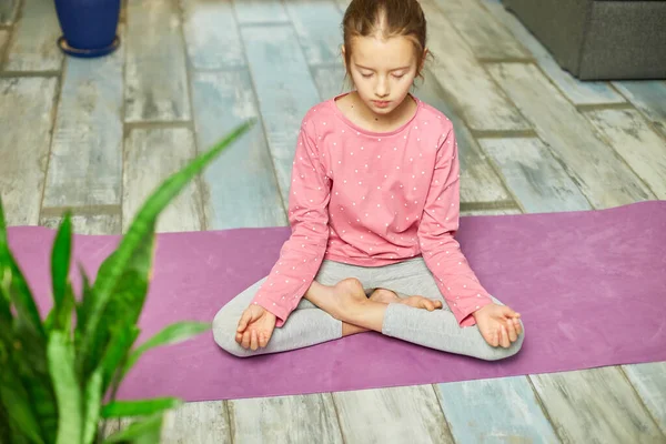 Söt Liten Flicka Sitter Träningsmatta Lotusposition Medan Gör Yoga Hemma — Stockfoto