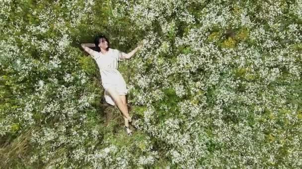 Drone aerial view of relax woman in dress lying on flower blooming meadow — Stock Video