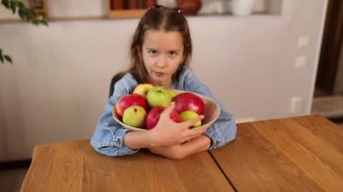 Açgözlülük Küçük mutlu kız evde meyve kasesi, sağlıklı çocuk atıştırmalıkları, evde sağlıklı yiyecekler, meyve ve vitaminleri sever..