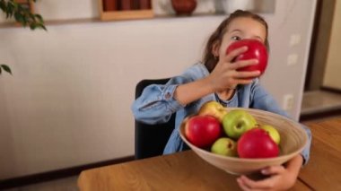 Küçük mutlu kız elinde meyve kasesi, evde sağlıklı çocuk atıştırması, evde sağlıklı yemekler, meyve ve vitaminleri sever..
