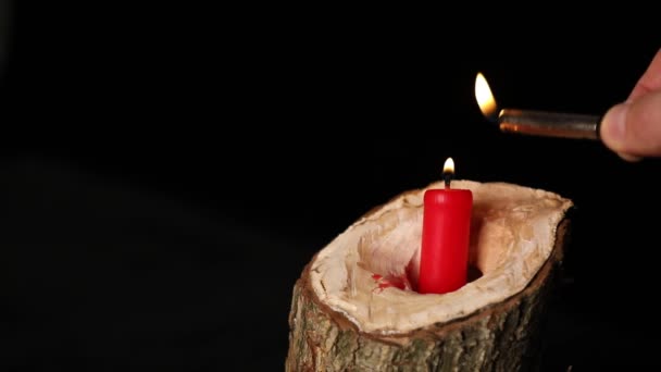 사람은 촛대검은 과붉은 촛불을 촛불에 놓는다 — 비디오