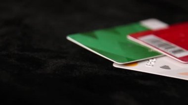 Kredi kartı, siyah arkaplan üzerine seçici bir odaklanma ile kapatılıyor. Ödeme altını, ödeme, satın alma