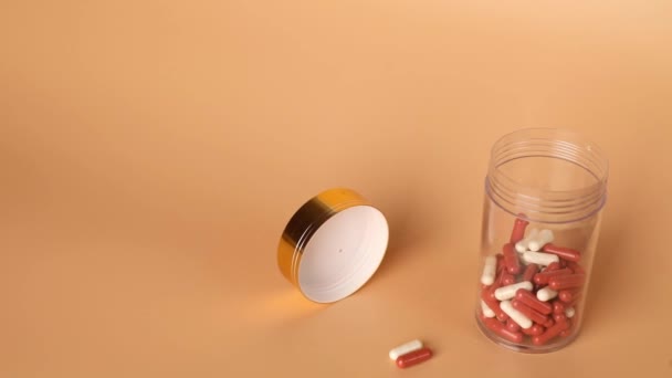 Piros Fehér Tabletták Tabletták Kiesnek Egy Üvegből Asztalon Gyógyszeripari Koncepció — Stock videók