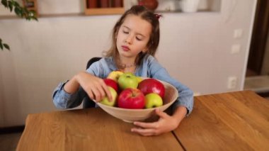 Küçük mutlu kız elinde meyve kasesi, evde sağlıklı çocuk atıştırması, evde sağlıklı yemekler, meyve ve vitaminleri sever..