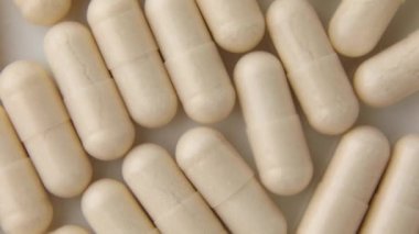 Döndürme makrosu Beyaz bej kapsül hapları, tabletler, üst görünüm