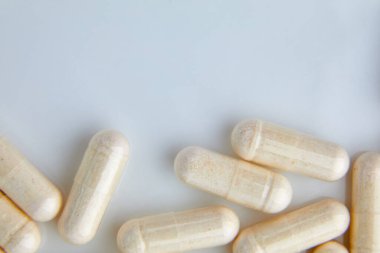 Düz konum makro beyaz bej kapsül hapları, tabletler, üst görünüm, doku arka plan farmasötik endüstrisi konsepti, kopyalama alanı.