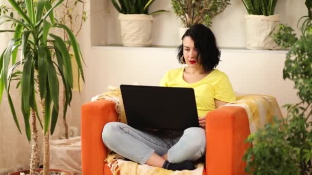 Женщина Помощью Поиск Ноутбука Оранжевом Кресле Дома Проверка Социальных Сетей — стоковое видео