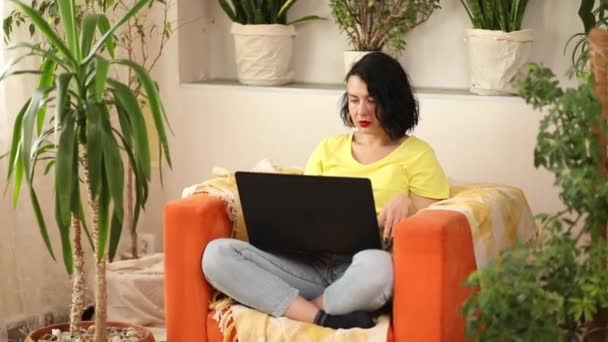 Женщина Помощью Поиск Ноутбука Покупки Интернете Заказ Доставки Оранжевом Кресле — стоковое видео