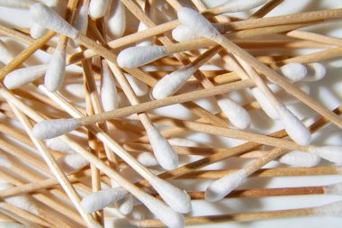 Beyaz arka planda çevre dostu pamuklar, bambu pamuk tomurcukları, tahta çubuklar, kulak temizleme için tahta çubuklar, kopyalama alanı.