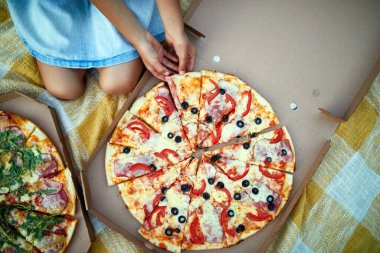 Pizza paylaşımı, küçük kız elleri açık hava kutusundan pizza almak aile pikniği, akşam yemeğinde pizza yemek, fast food teslimatı..