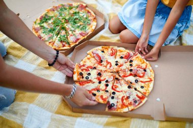 Pizza paylaşımı, açık hava kutusundan pizza alan eller, aile pikniği, akşam yemeğinde pizza yemek, fast food teslimatı..