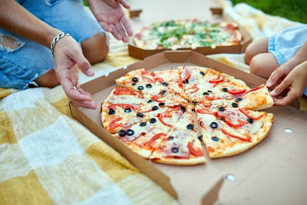 Pizza paylaşımı, açık hava kutusundan pizza alan eller, aile pikniği, akşam yemeğinde pizza yemek, fast food teslimatı..