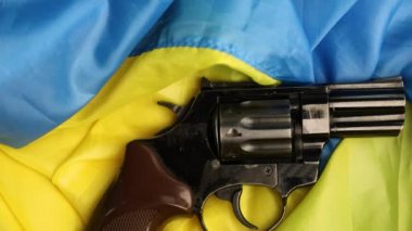 Erkek eli tabanca, Ukrayna bayrağı, arka plan Ukrayna savaşı, Savaşı durdurun, Özgürlük, bağımsızlık ülkesi, Ukrayna zaferi