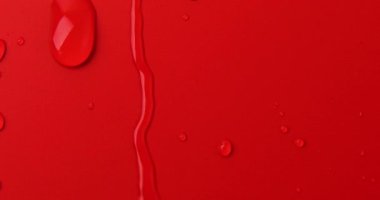Kırmızı arkaplanda soyut su damlaları, makro, baloncuklar yaklaşın, kozmetik sıvı damlaları, düz döşeme deseni.