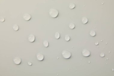 Gri arkaplanda soyut su damlaları, makro, baloncuklar, yakın plan, kozmetik sıvı damlaları, düz döşeme deseni.